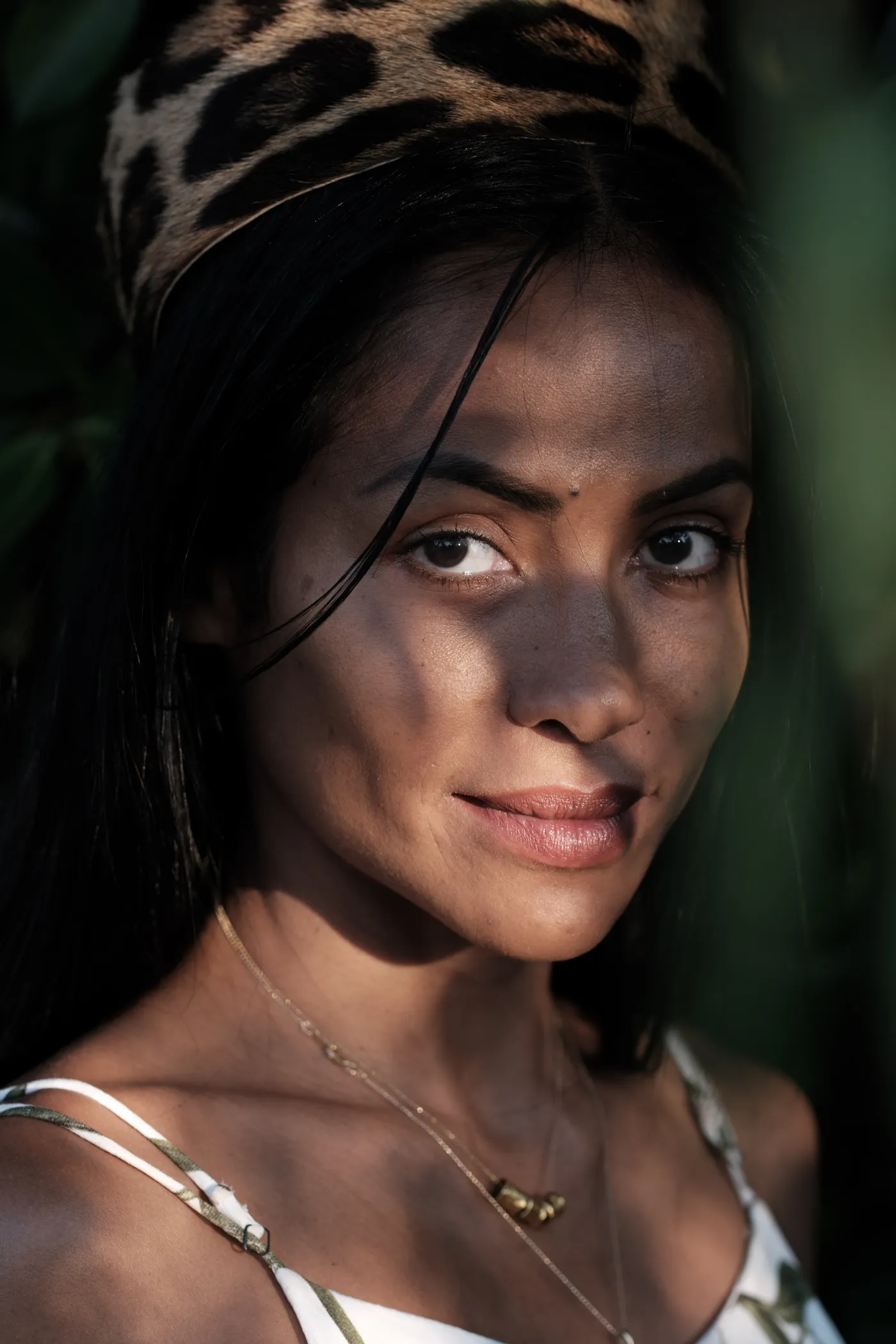 Tatiana Aya Tupinambá, in a jaguar-print headdress, looking into the camera
